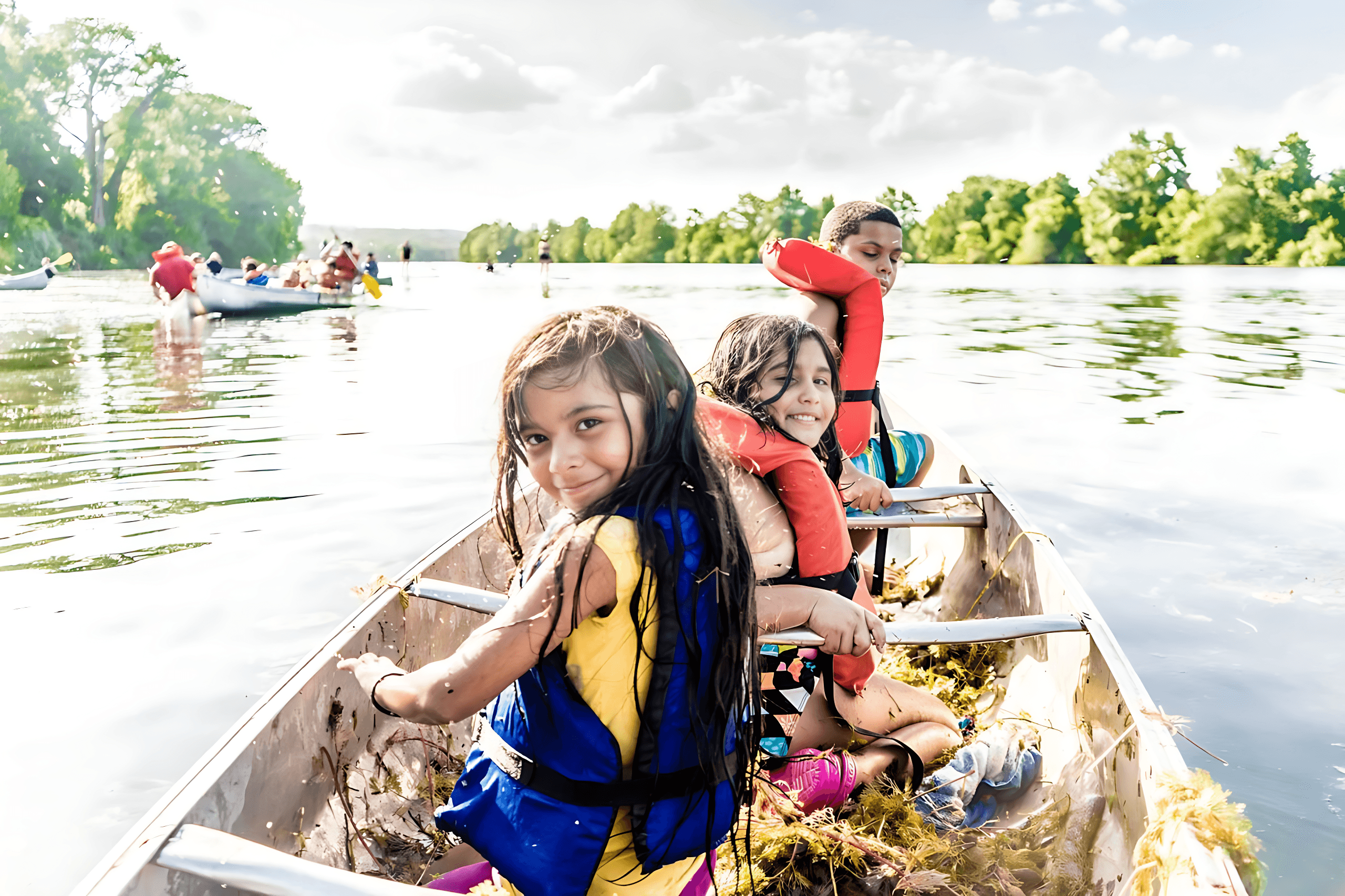 Children smiling while canoeing on Lady Bird Lake in Austin