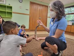 A naturalist showing a snake to children during a program at the Austin Nature & Science Center