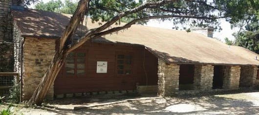 The historic stone-and-wood Girl Scout cabin nestled among trees in Zilker Park