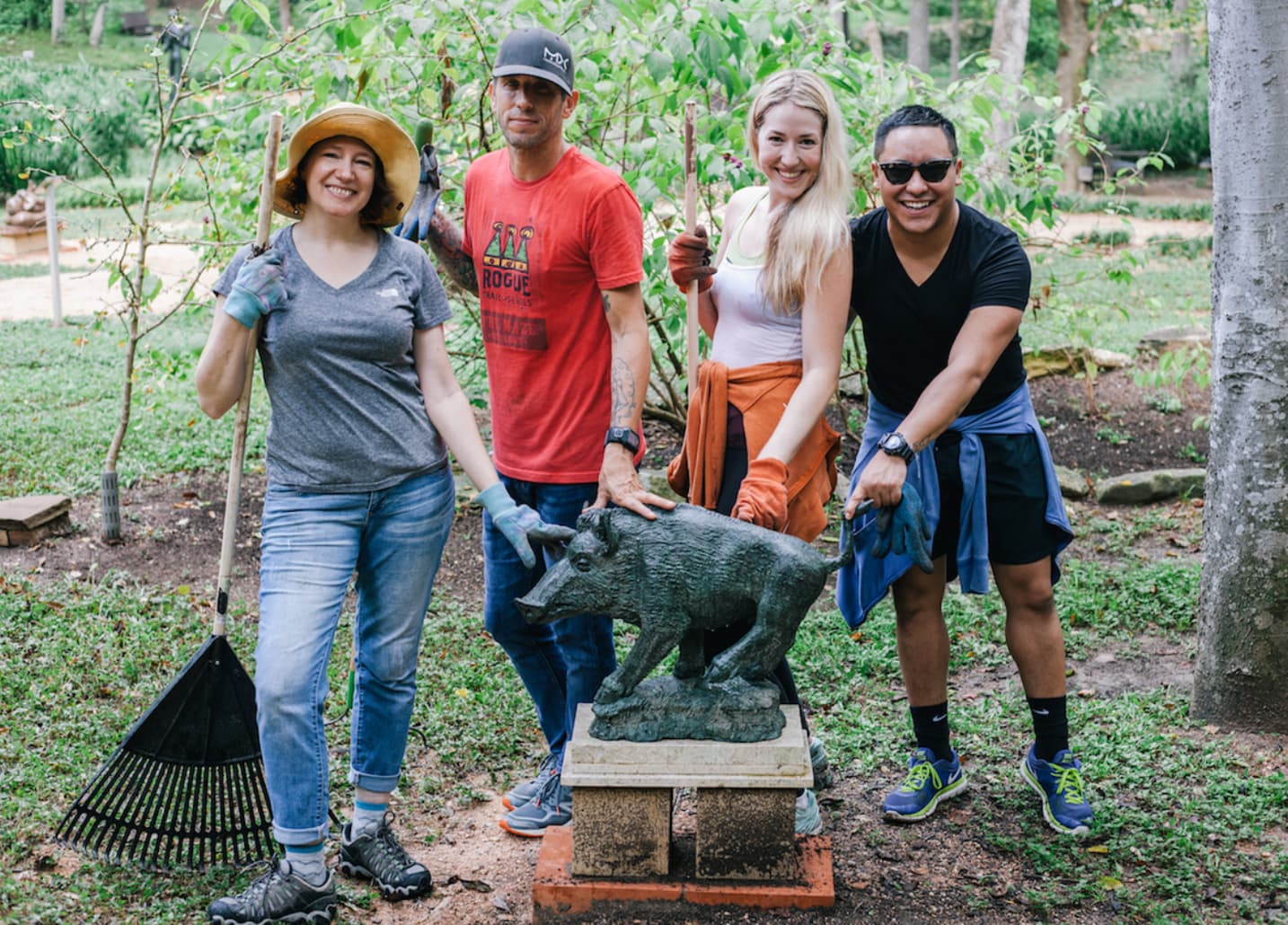 Visitors beside a bronze boar sculpture in the UMLAUF Sculpture Garden